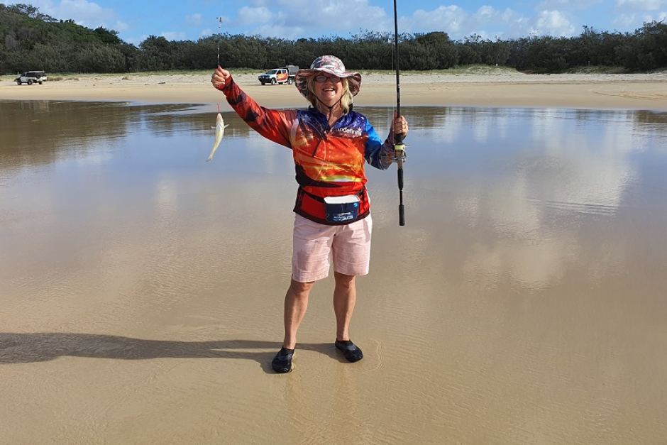 Adele Hockey catches a fish on Fraser Island while the couple are in lockdown on the island